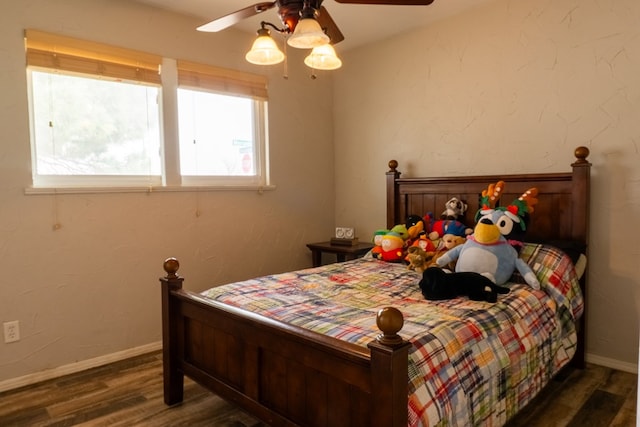 bedroom with ceiling fan, baseboards, and wood finished floors