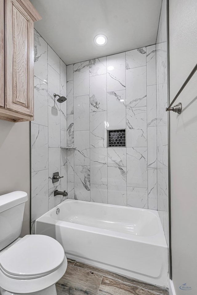 bathroom featuring toilet and tiled shower / bath combo