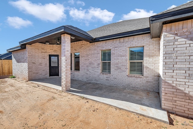 view of side of property with ceiling fan and a patio