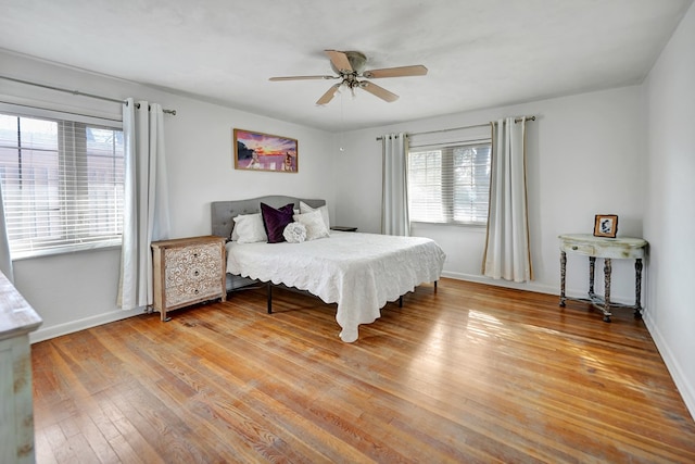 bedroom with wood-type flooring, ceiling fan, and baseboards