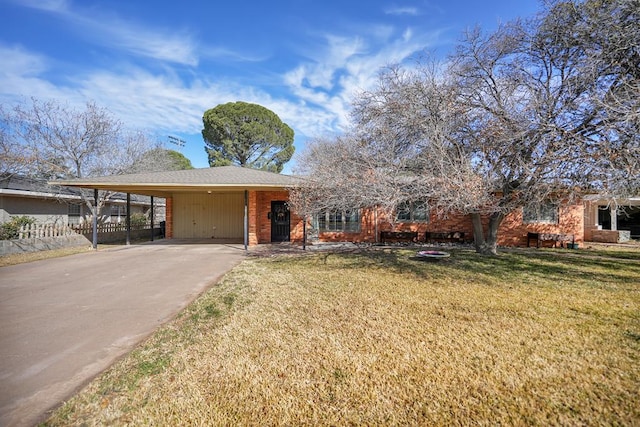 view of front of house featuring driveway, an attached carport, fence, a front yard, and brick siding