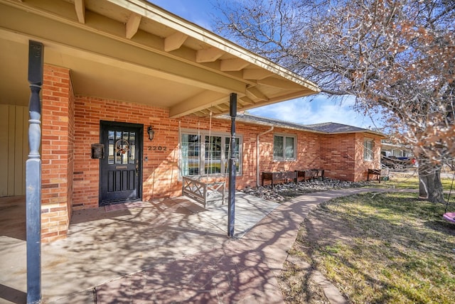 doorway to property featuring brick siding