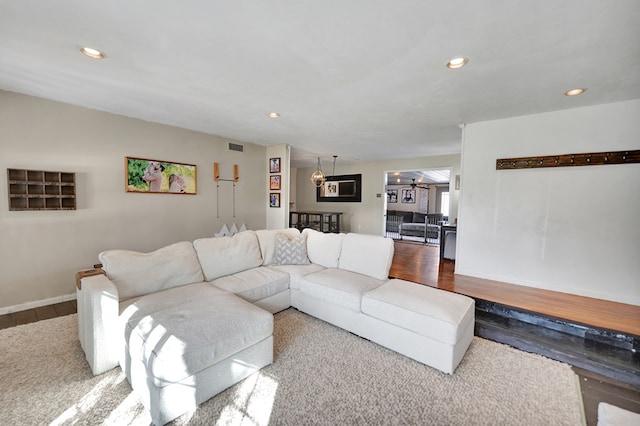 living room featuring baseboards, wood finished floors, and recessed lighting