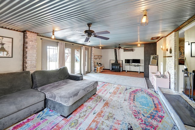 carpeted living area featuring french doors and a wood stove