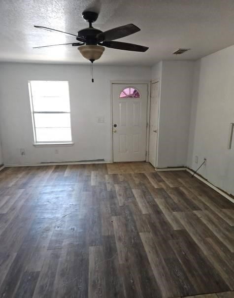 interior space with baseboards, ceiling fan, visible vents, and wood finished floors