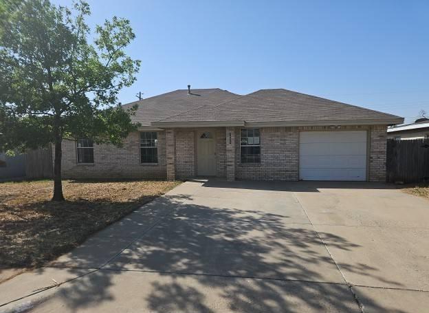 ranch-style home with fence, an attached garage, concrete driveway, and brick siding
