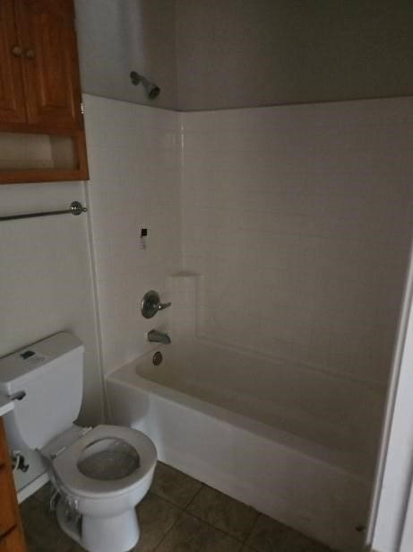 bathroom with tile patterned floors, bathtub / shower combination, and toilet