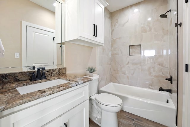 full bathroom with hardwood / wood-style flooring, vanity, toilet, and tiled shower / bath