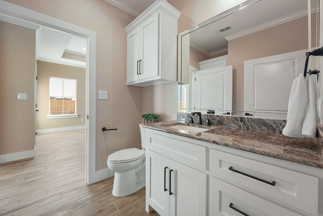 bathroom with toilet, vanity, wood-type flooring, and ornamental molding