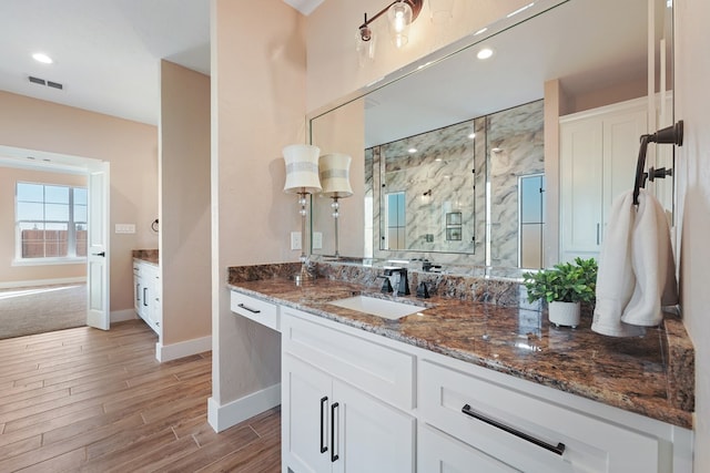 bathroom featuring wood-type flooring, vanity, and a shower with shower door