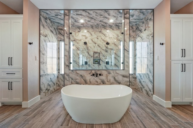 bathroom featuring wood-type flooring and shower with separate bathtub