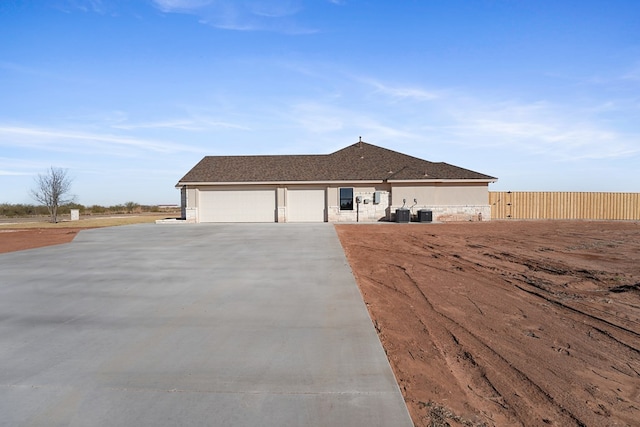 view of front of house featuring a garage and central AC unit