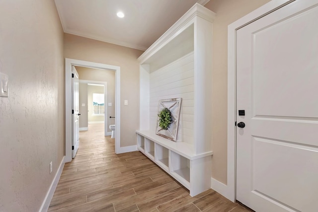 mudroom with crown molding and light hardwood / wood-style flooring