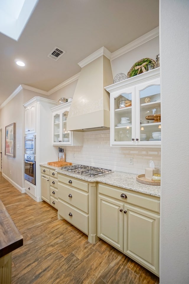 kitchen featuring stainless steel appliances, dark wood-style flooring, visible vents, tasteful backsplash, and custom range hood