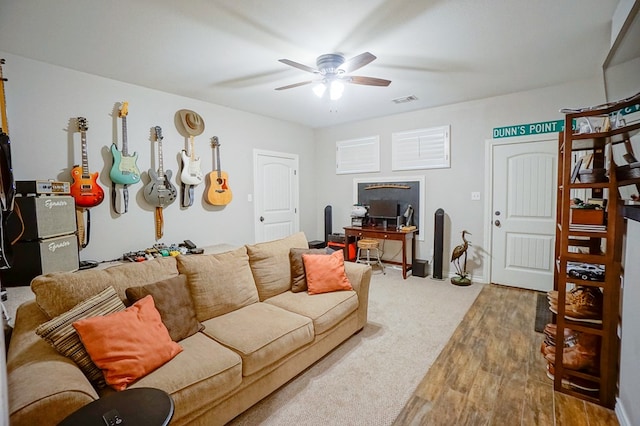 living room with visible vents, ceiling fan, and wood finished floors