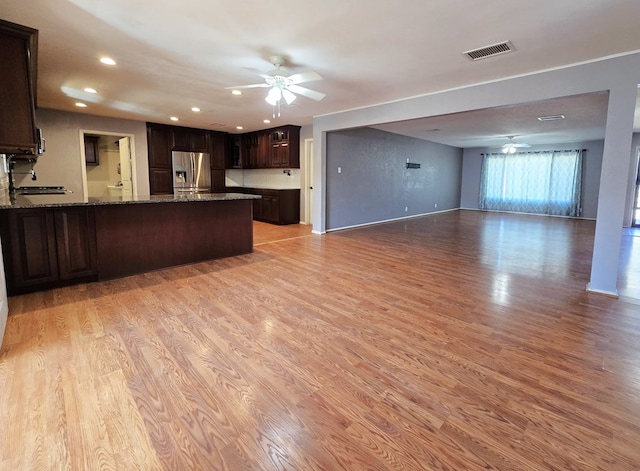 kitchen with light wood-style flooring, open floor plan, stainless steel fridge, dark brown cabinets, and ceiling fan