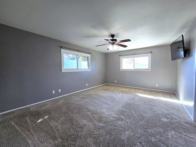 spare room featuring carpet, baseboards, and ceiling fan