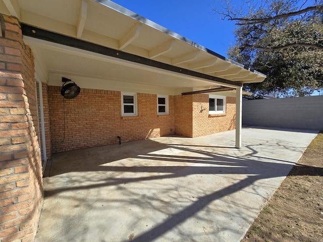 view of patio / terrace with an attached carport, fence, and driveway