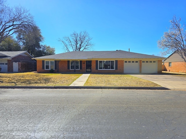 view of front facade featuring driveway, brick siding, and an attached garage