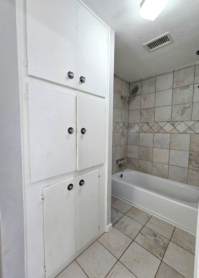 full bath with washtub / shower combination, visible vents, and a textured ceiling