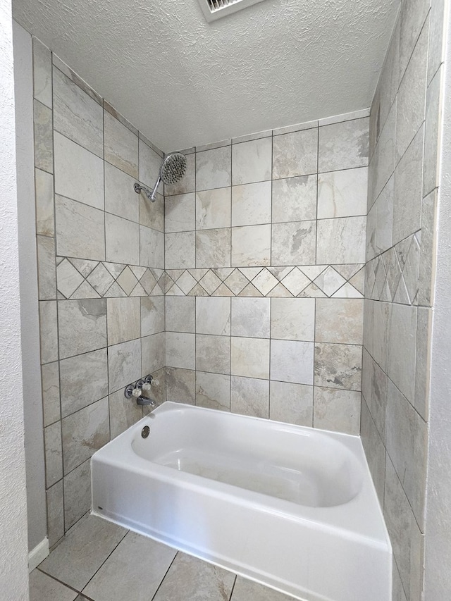 bathroom with tile patterned floors, a textured ceiling, and shower / bath combination