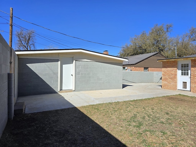 exterior space featuring an outbuilding, fence, and a patio area