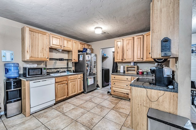 kitchen featuring dark countertops, light tile patterned floors, light brown cabinets, and stainless steel appliances