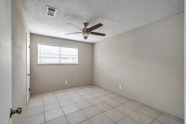 empty room featuring visible vents, a textured ceiling, light tile patterned flooring, and a ceiling fan