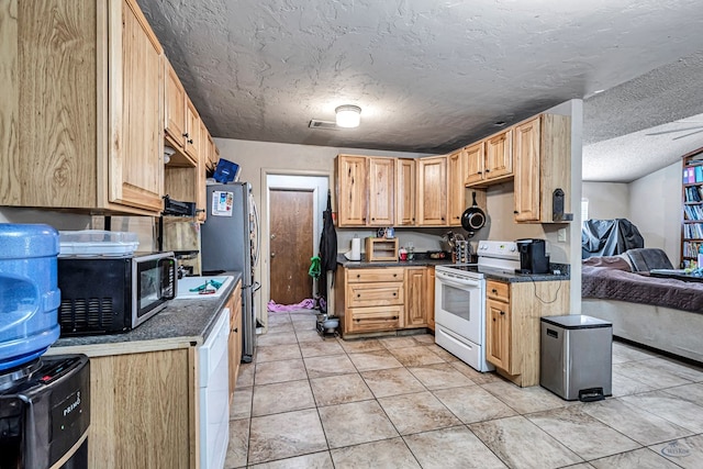 kitchen featuring dark countertops, light brown cabinetry, freestanding refrigerator, a textured ceiling, and white electric range