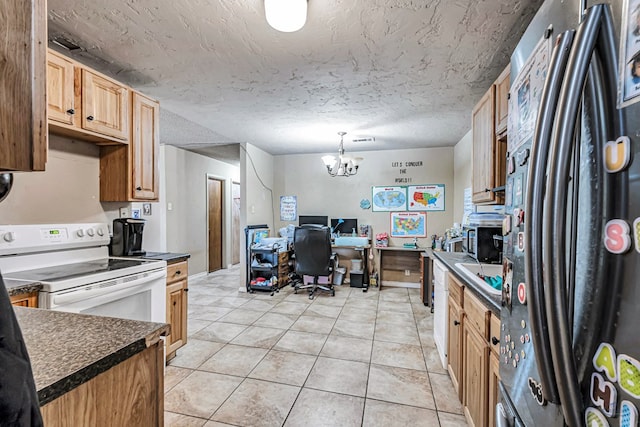 kitchen featuring electric stove, a textured ceiling, dark countertops, freestanding refrigerator, and light tile patterned flooring