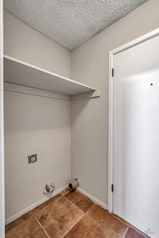 laundry area featuring electric dryer hookup, a textured ceiling, and laundry area