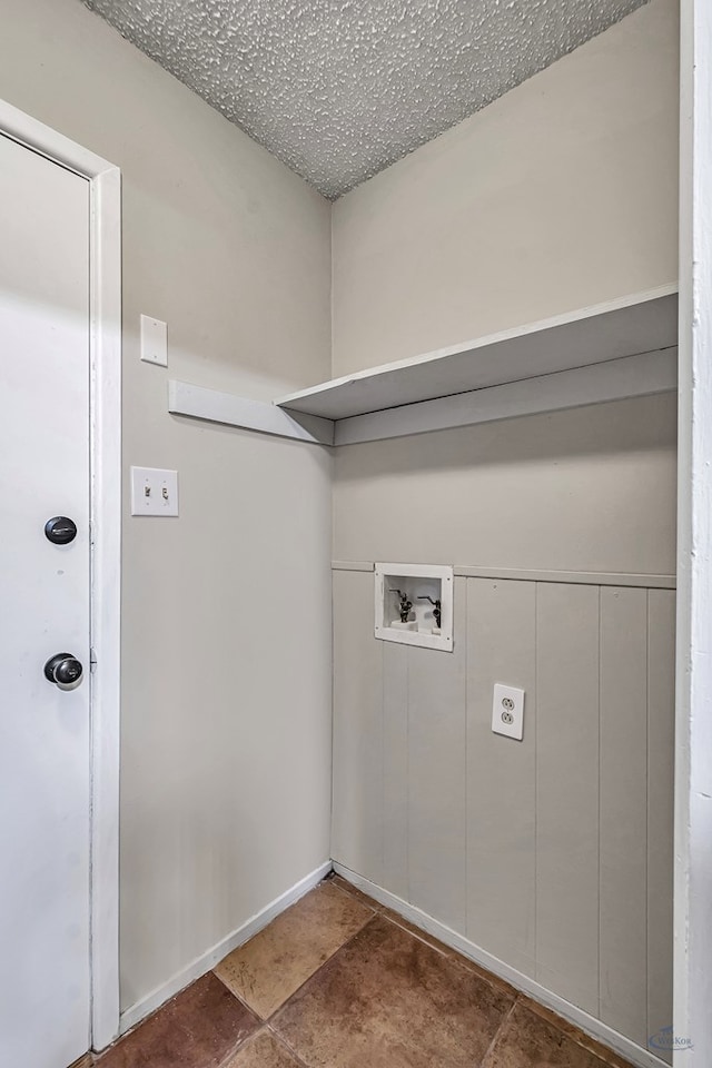 clothes washing area with a textured ceiling, washer hookup, and laundry area