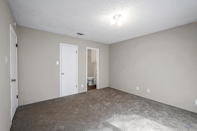 unfurnished bedroom featuring ensuite bath, visible vents, carpet flooring, and a textured ceiling