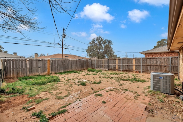 view of yard with central AC unit, a patio, and a fenced backyard