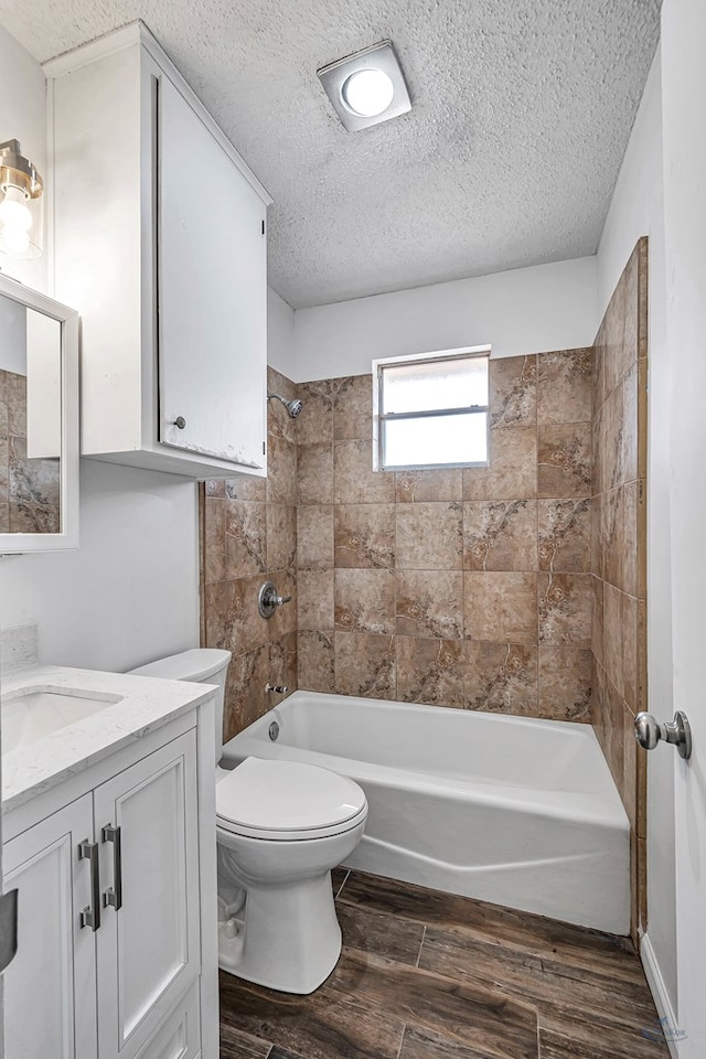 full bath featuring toilet, a textured ceiling, wood finished floors, shower / bath combination, and vanity