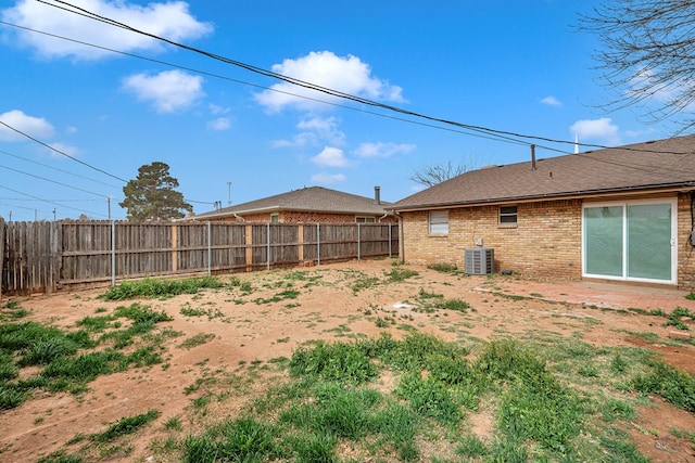 view of yard with central AC unit and a fenced backyard