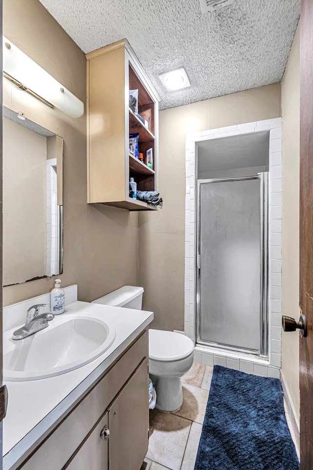 full bath with a textured ceiling, a stall shower, vanity, and toilet