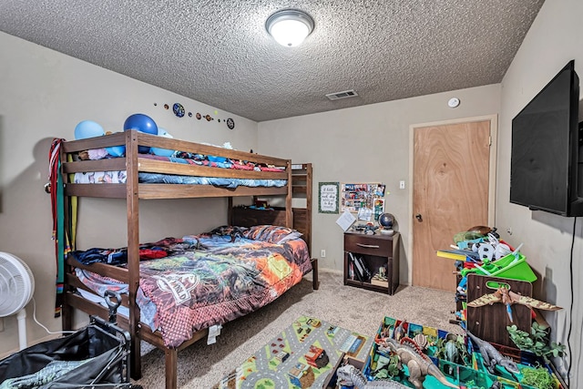 bedroom with carpet flooring, visible vents, and a textured ceiling