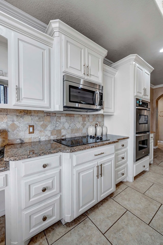 10104 E County Rd 103, Midland, TX 79706 - kitchen featuring appliances with stainless steel finishes, stone countertops, white cabinets, and crown molding