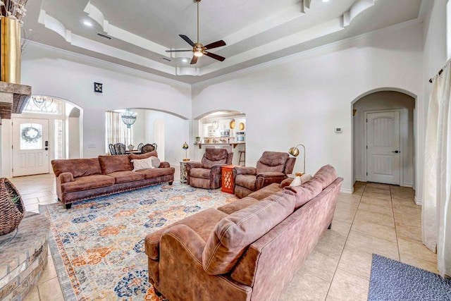 10104 E County Rd 103, Midland, TX 79706 - living area with arched walkways, ceiling fan, a towering ceiling, light tile patterned floors, and a raised ceiling