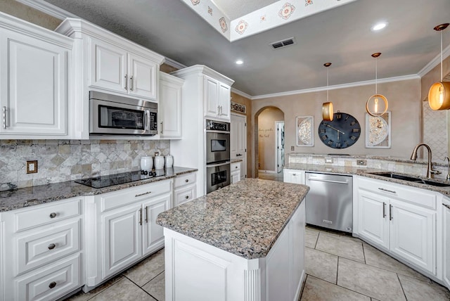10104 E County Rd 103, Midland, TX 79706 - kitchen with appliances with stainless steel finishes, a sink, tasteful backsplash, a kitchen island, and white cabinetry