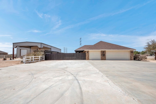 10104 E County Rd 103, Midland, TX 79706 - view of front of property with brick siding, an outbuilding, driveway, and an attached garage