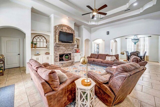 10104 E County Rd 103, Midland, TX 79706 - living area with arched walkways, a ceiling fan, light tile patterned floors, a raised ceiling, and a towering ceiling