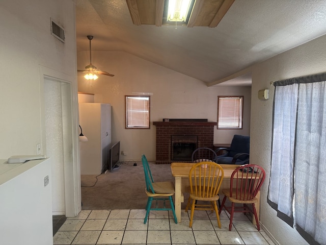 901 N D St, Midland, TX 79701 - dining room featuring lofted ceiling, a brick fireplace, a ceiling fan, and light colored carpet