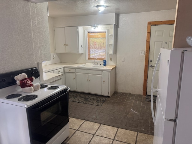 901 N D St, Midland, TX 79701 - kitchen with electric range oven, freestanding refrigerator, a sink, light countertops, and white cabinets