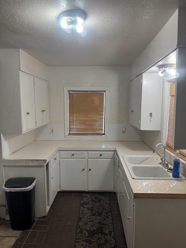 901 N D St, Midland, TX 79701 - kitchen with a sink, a textured ceiling, white cabinets, and light countertops