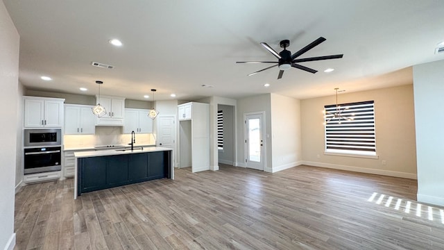 13223 E County Rd 110, Midland, TX 79706 - kitchen with a sink, recessed lighting, stainless steel microwave, white cabinets, and light wood-style flooring