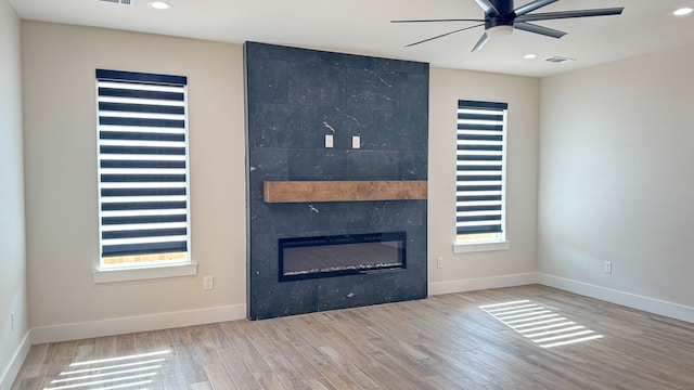 13223 E County Rd 110, Midland, TX 79706 - unfurnished living room featuring a ceiling fan, wood finished floors, a high end fireplace, recessed lighting, and baseboards