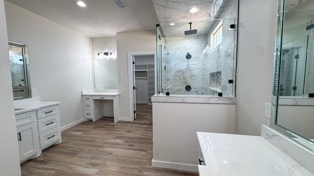13223 E County Rd 110, Midland, TX 79706 - bathroom with a marble finish shower, wood finished floors, vanity, a spacious closet, and baseboards