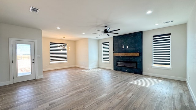 13223 E County Rd 110, Midland, TX 79706 - unfurnished living room with ceiling fan, a premium fireplace, light wood-type flooring, plenty of natural light, and recessed lighting